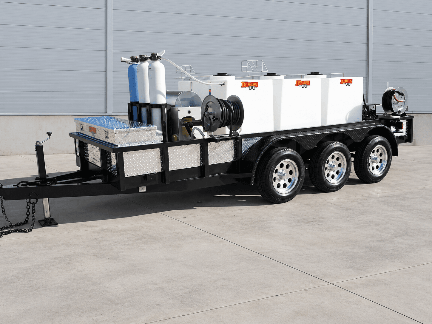 DBP 600 trailer with three white water tanks, cylindrical treatment tanks, and a hose reel on a triple-axle frame