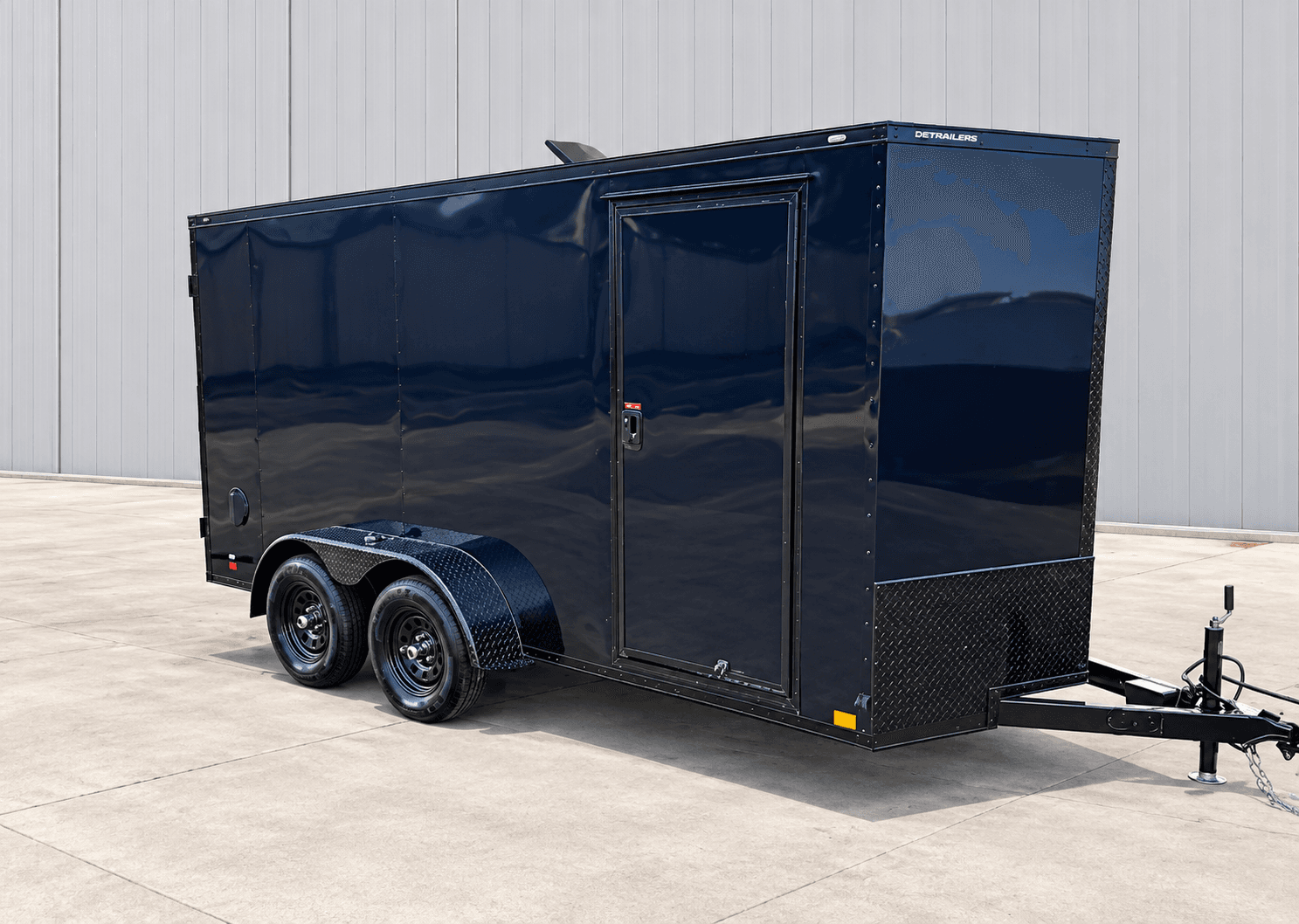 DEP Series black enclosed cargo trailer parked on a driveway, rear-quarter view showing its tandem axles