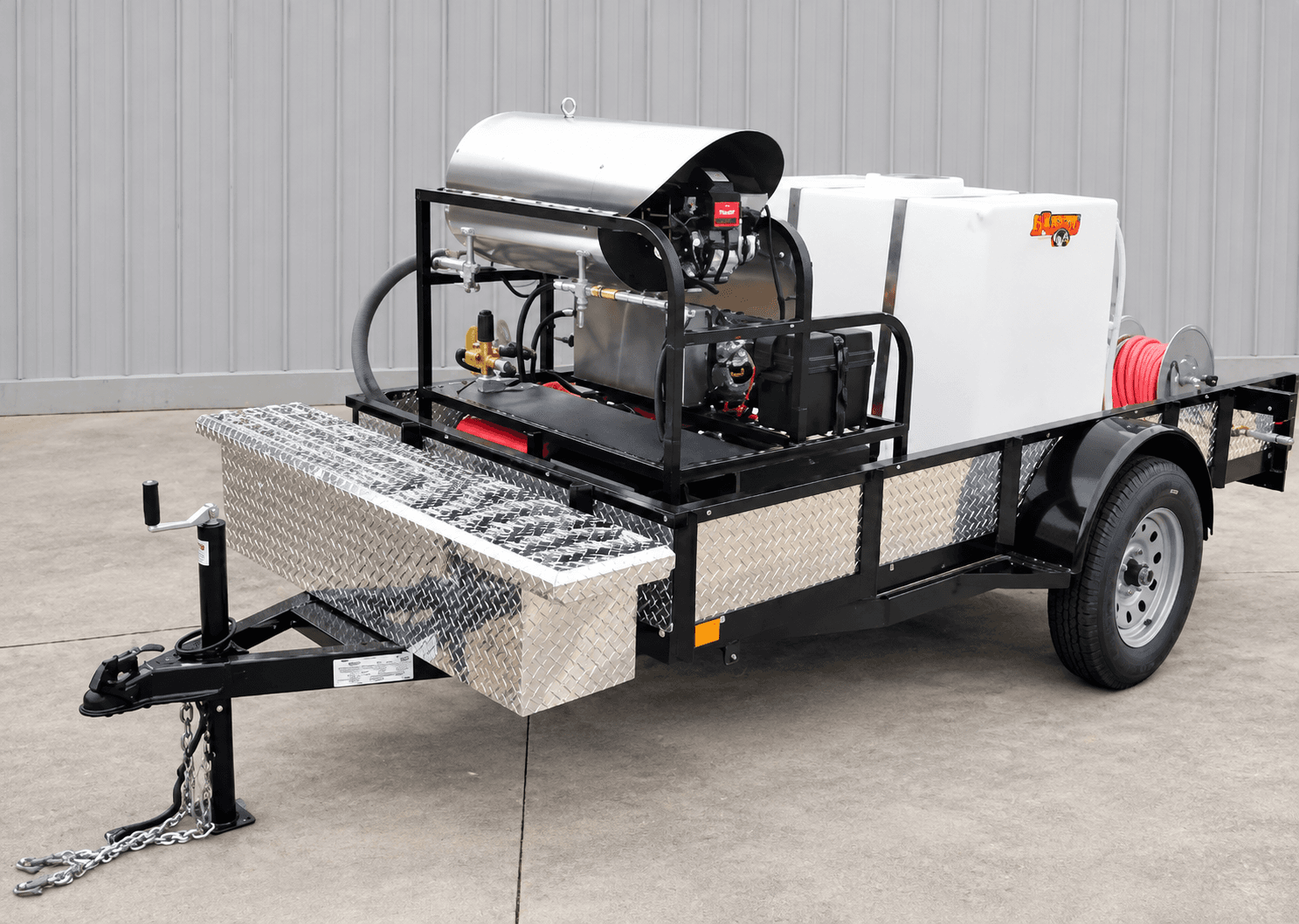 Dynamo open utility trailer with a white water tank, stainless burner coil, hose reel, and diamond-plate toolbox
